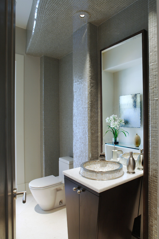 Inspiration for a small contemporary white tile and mosaic tile powder room remodel in Atlanta with flat-panel cabinets, dark wood cabinets, a one-piece toilet, beige walls, a vessel sink and quartz countertops