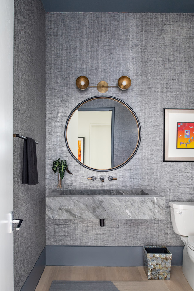 Inspiration för ett funkis toalett, med en toalettstol med separat cisternkåpa, grå väggar, ljust trägolv, ett väggmonterat handfat och beiget golv