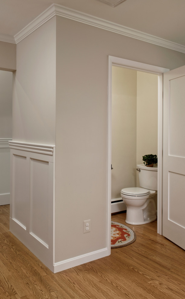 Powder room - small transitional medium tone wood floor powder room idea in DC Metro with a two-piece toilet and a built-in vanity