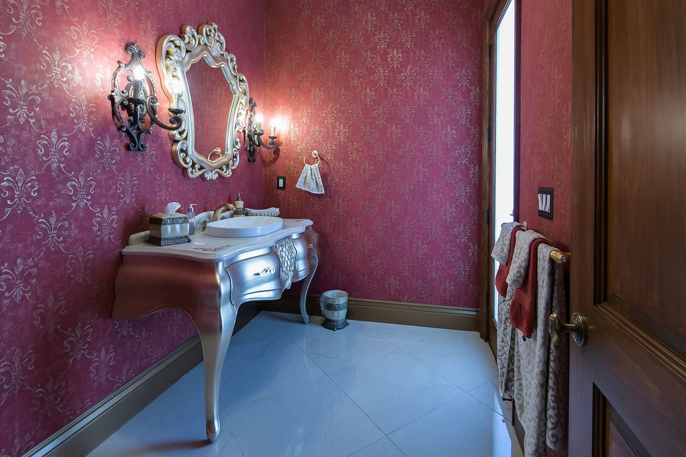 Kleine Mediterrane Gästetoilette mit verzierten Schränken, grauen Schränken, Toilette mit Aufsatzspülkasten, roter Wandfarbe, Porzellan-Bodenfliesen, Aufsatzwaschbecken und Mineralwerkstoff-Waschtisch in San Francisco