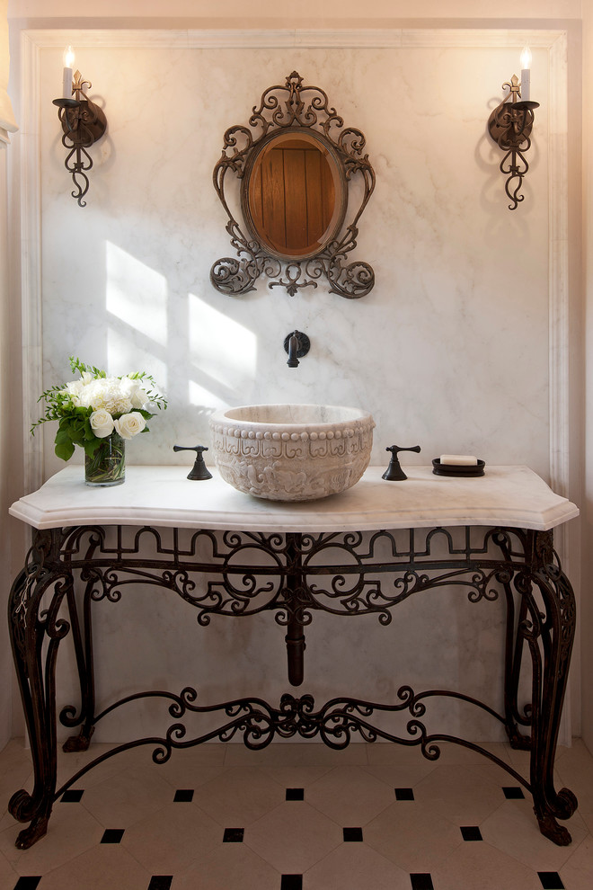 Пример оригинального дизайна: туалет в средиземноморском стиле с настольной раковиной и мраморной плиткой