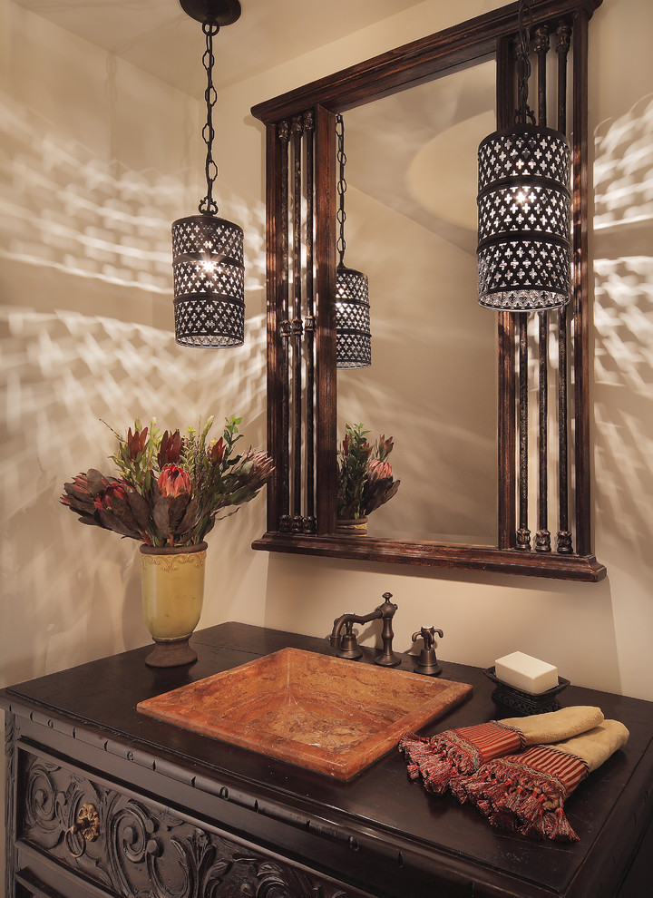 Powder room - mediterranean powder room idea in Phoenix with a drop-in sink, dark wood cabinets, wood countertops and brown countertops