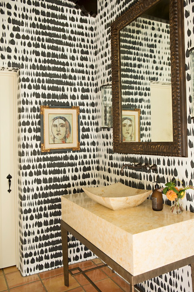 Imagen de aseo mediterráneo con lavabo sobreencimera, paredes multicolor y suelo de baldosas de terracota