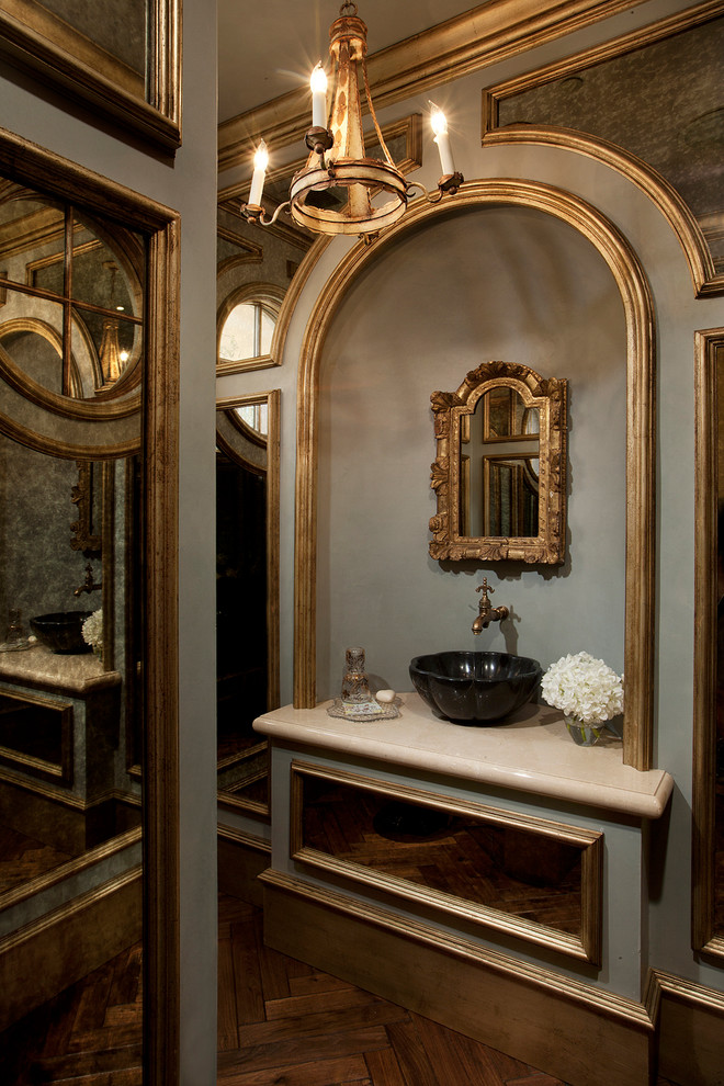 Inspiration for a small mediterranean medium tone wood floor powder room remodel in Phoenix with a vessel sink, marble countertops and gray walls