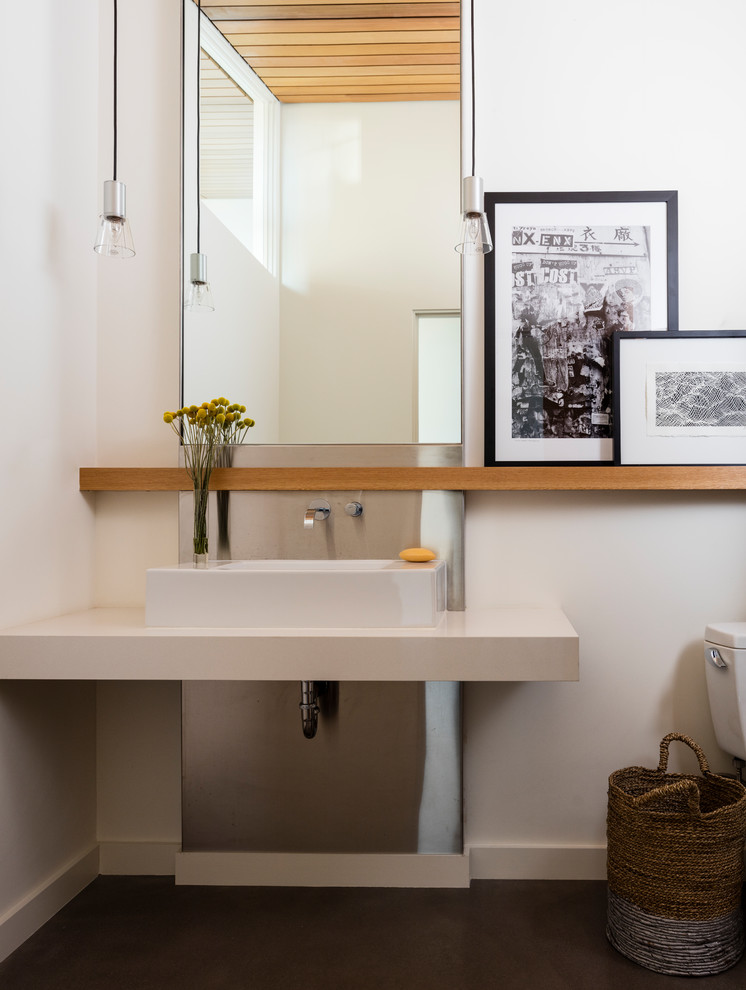 Moderne Gästetoilette mit weißer Wandfarbe, Betonboden, Aufsatzwaschbecken, Mineralwerkstoff-Waschtisch, grauem Boden und weißer Waschtischplatte in Seattle