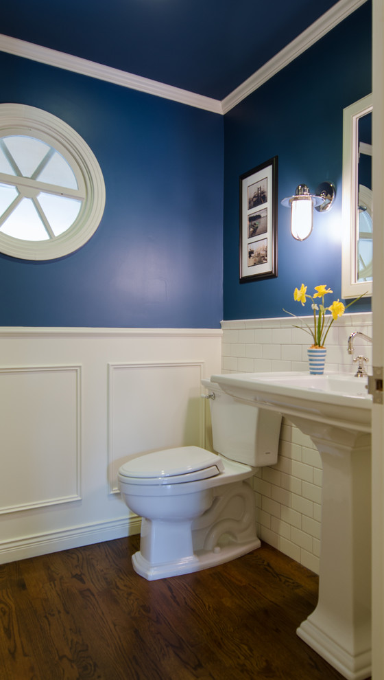 Example of a classic white tile and subway tile dark wood floor powder room design in Seattle with a pedestal sink, a two-piece toilet and blue walls