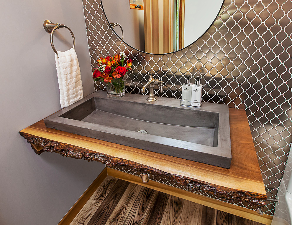 Powder room - mid-sized contemporary gray tile and ceramic tile medium tone wood floor and brown floor powder room idea in Detroit with a two-piece toilet, gray walls, a drop-in sink, wood countertops and beige countertops