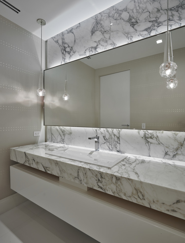 Mittelgroße Moderne Gästetoilette mit weißen Schränken, weißen Fliesen, Unterbauwaschbecken, Marmor-Waschbecken/Waschtisch und grauer Wandfarbe in Miami