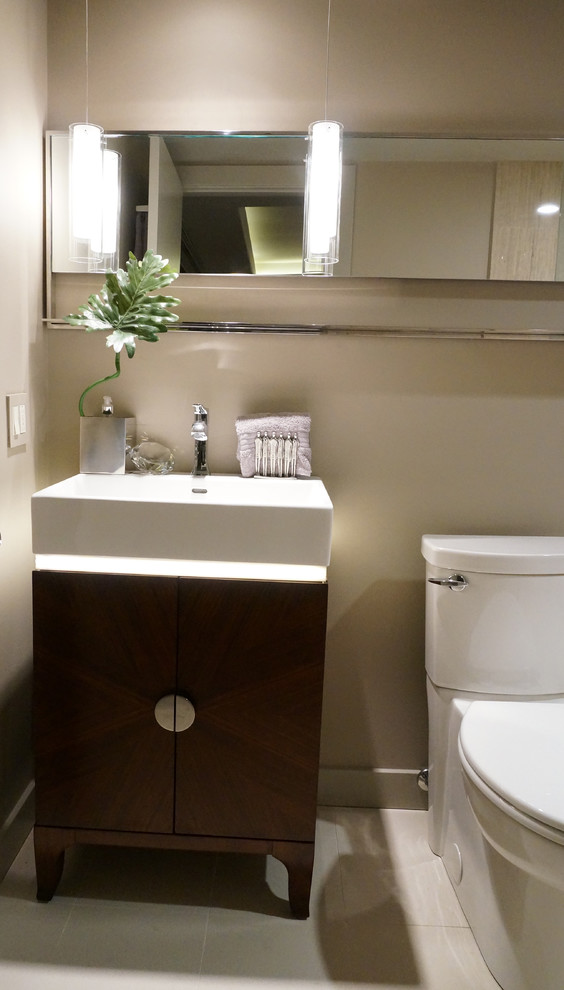 Example of a small trendy ceramic tile powder room design in Chicago with flat-panel cabinets, dark wood cabinets, a two-piece toilet, beige walls and an undermount sink