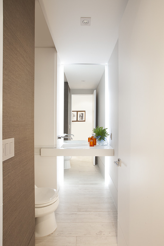 This is an example of a contemporary cloakroom in Miami with porcelain flooring.