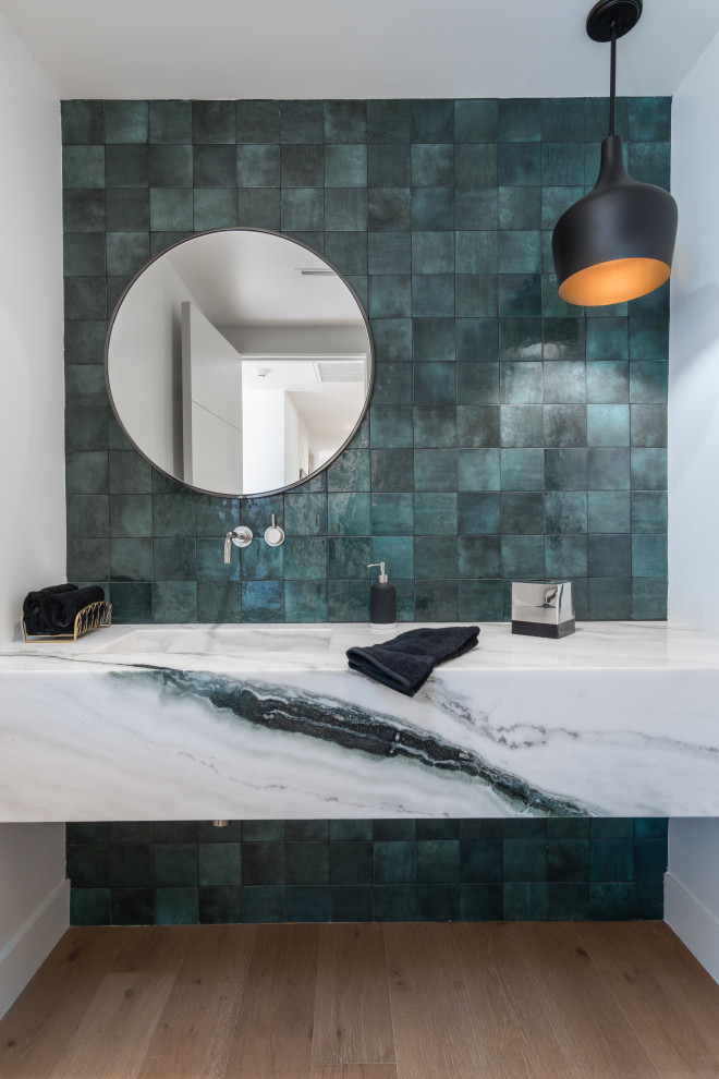 Photo of a retro cloakroom in Los Angeles with green tiles, white walls, light hardwood flooring, an integrated sink, beige floors and multi-coloured worktops.