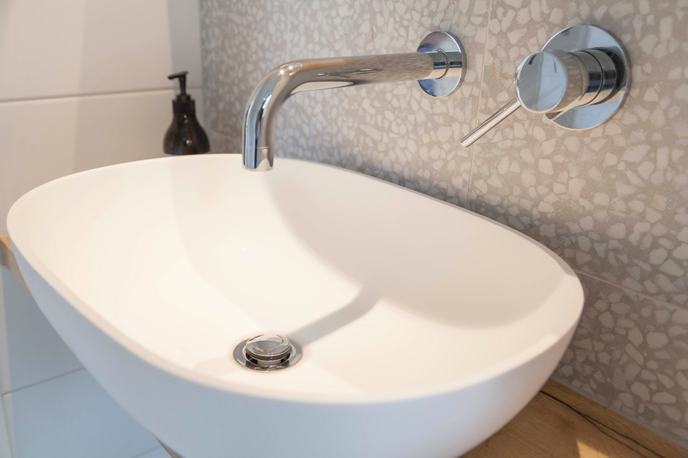 Example of a mid-sized 1960s beige tile and ceramic tile powder room design in Melbourne with white walls, a vessel sink, wood countertops and brown countertops