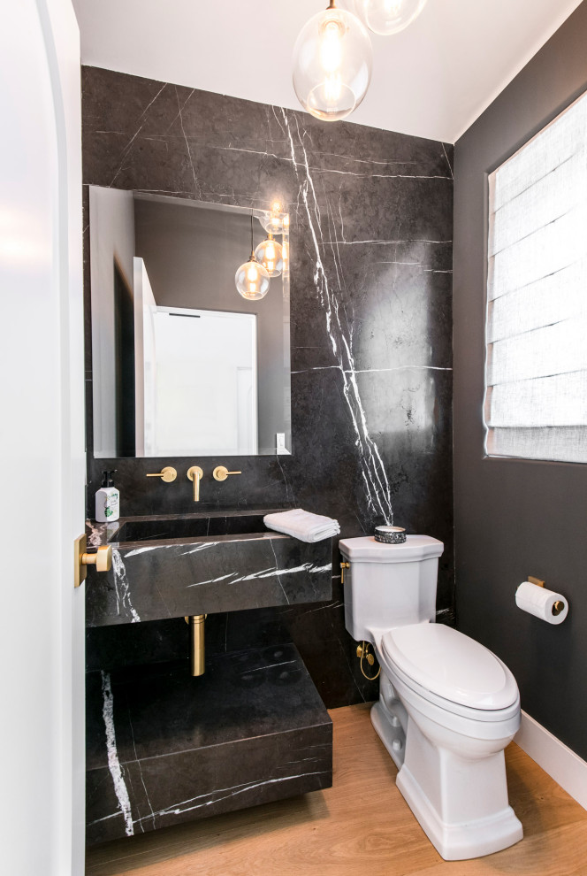 Idéer för att renovera ett mellanstort vintage svart svart toalett, med svarta skåp, en toalettstol med hel cisternkåpa, svart och vit kakel, marmorkakel, vita väggar, ljust trägolv, ett integrerad handfat, marmorbänkskiva och brunt golv