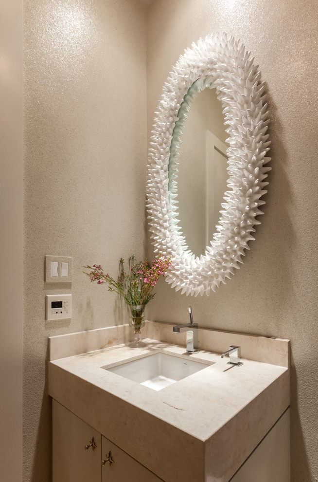 Photo of a small contemporary cloakroom in Houston with flat-panel cabinets, light wood cabinets, beige tiles, beige walls, ceramic flooring, a built-in sink and travertine worktops.