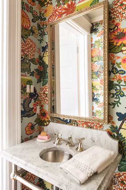 Cette image montre un WC et toilettes bohème avec un mur multicolore, un plan vasque et un plan de toilette en marbre.