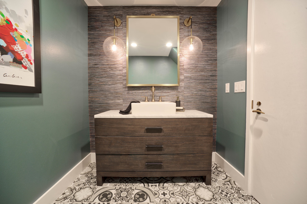 Moderne Gästetoilette mit verzierten Schränken, dunklen Holzschränken, grüner Wandfarbe, Aufsatzwaschbecken, buntem Boden und weißer Waschtischplatte in Tampa