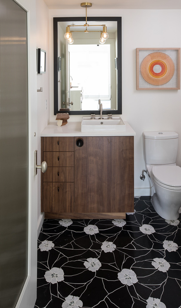 Cette image montre un petit WC et toilettes vintage en bois foncé avec un placard à porte plane, un sol en carrelage de terre cuite, un plan de toilette en quartz modifié, un sol noir, un plan de toilette blanc, WC à poser, un mur blanc et une vasque.