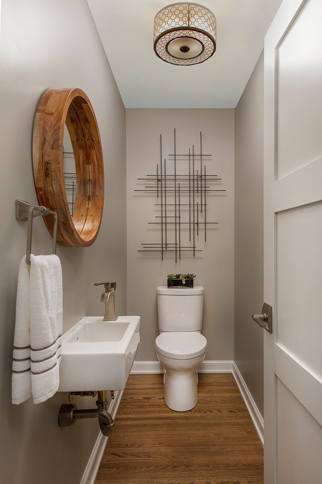 Foto de aseo tradicional renovado pequeño con paredes grises, suelo de madera en tonos medios, lavabo suspendido y sanitario de dos piezas
