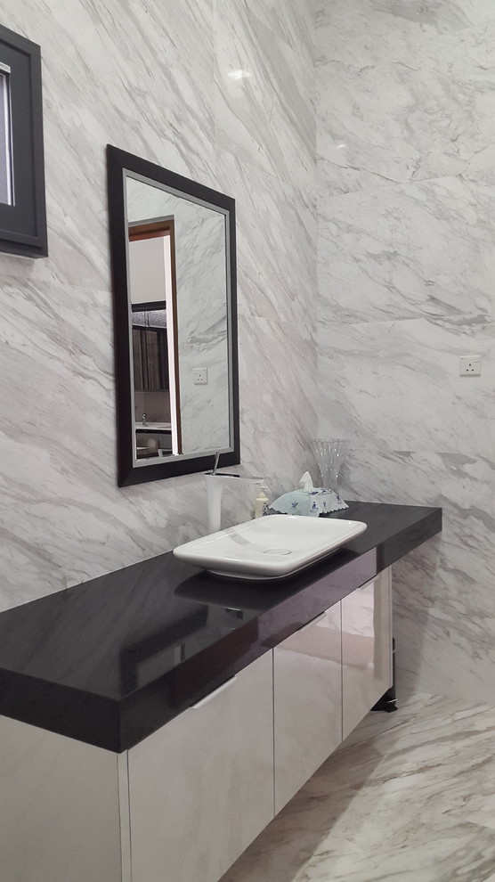 Idee per un bagno di servizio moderno di medie dimensioni con WC sospeso, lastra di pietra, pavimento in marmo, lavabo a bacinella e top in quarzo composito