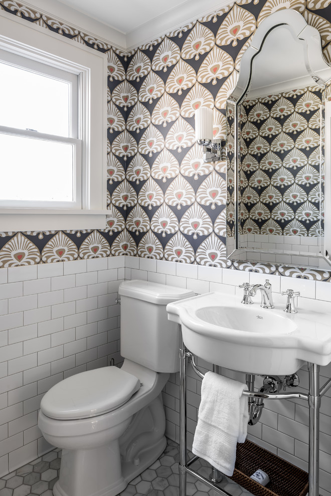 Diseño de aseo clásico con sanitario de dos piezas, paredes multicolor, suelo de mármol y lavabo tipo consola
