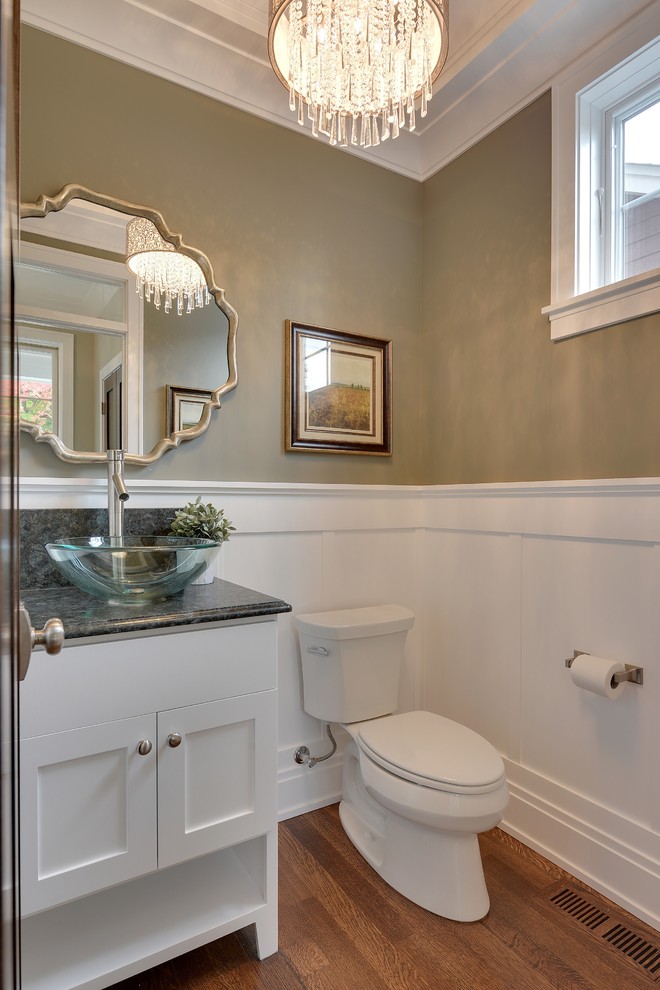 Inspiration for a mid-sized transitional medium tone wood floor powder room remodel in Minneapolis with a vessel sink, recessed-panel cabinets, white cabinets, a two-piece toilet, beige walls and gray countertops