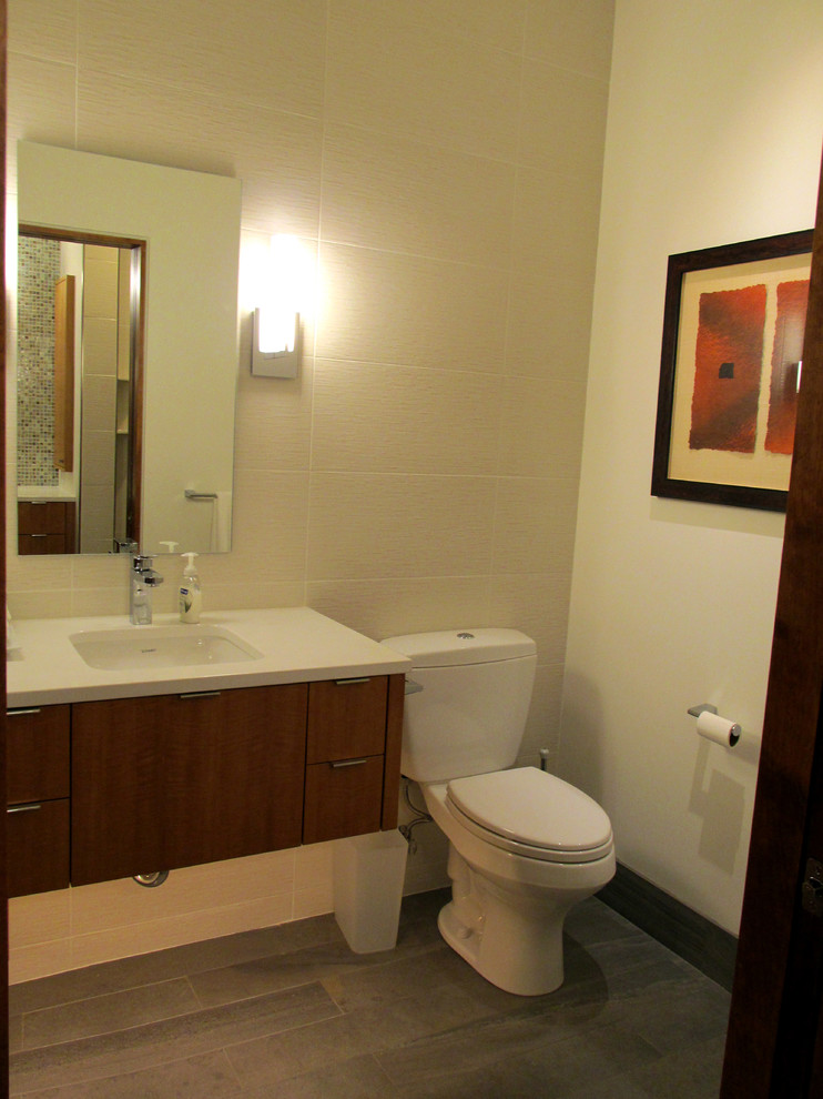 Design ideas for a medium sized modern cloakroom in Minneapolis with flat-panel cabinets, medium wood cabinets, a two-piece toilet, white tiles, porcelain tiles, white walls, porcelain flooring, a submerged sink and engineered stone worktops.