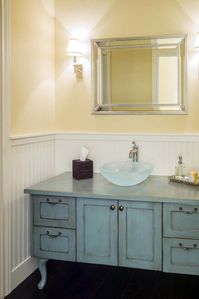 Klassisk inredning av ett mellanstort blå blått toalett, med möbel-liknande, skåp i slitet trä, beige väggar, mörkt trägolv, ett fristående handfat, träbänkskiva och brunt golv