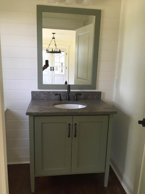 Small transitional medium tone wood floor powder room photo in Other with shaker cabinets, green cabinets, an undermount sink and marble countertops