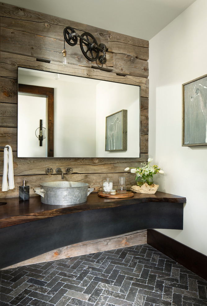 デンバーにあるラスティックスタイルのおしゃれなトイレ・洗面所 (白い壁、ベッセル式洗面器、木製洗面台、黒い床) の写真