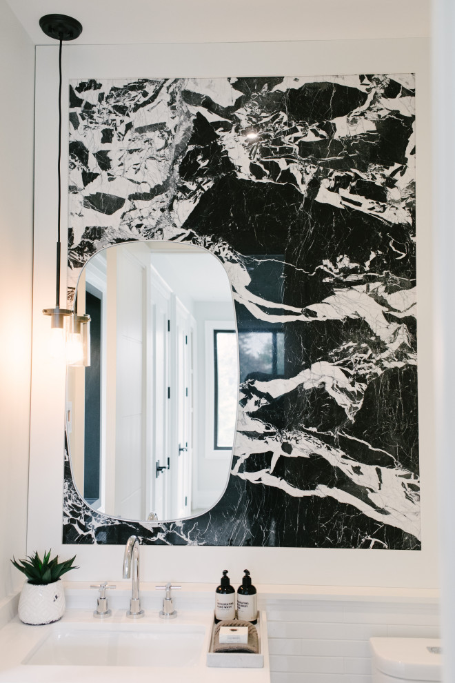 Idée de décoration pour un WC et toilettes minimaliste de taille moyenne avec un placard à porte plane, des portes de placard noires, un mur blanc, un sol en calcaire, une vasque, un plan de toilette en marbre, un sol noir et un plan de toilette noir.
