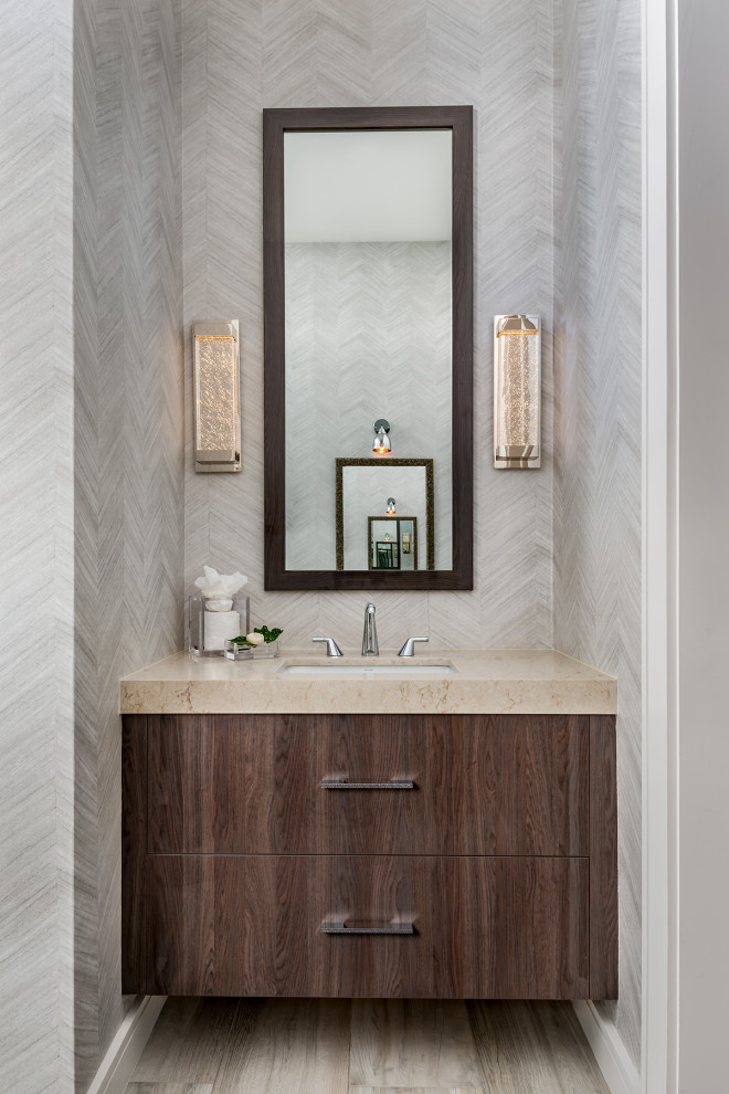 Photo of a medium sized contemporary cloakroom in Toronto with flat-panel cabinets, a one-piece toilet, multi-coloured walls, porcelain flooring, an integrated sink, beige worktops, dark wood cabinets, engineered stone worktops and multi-coloured floors.