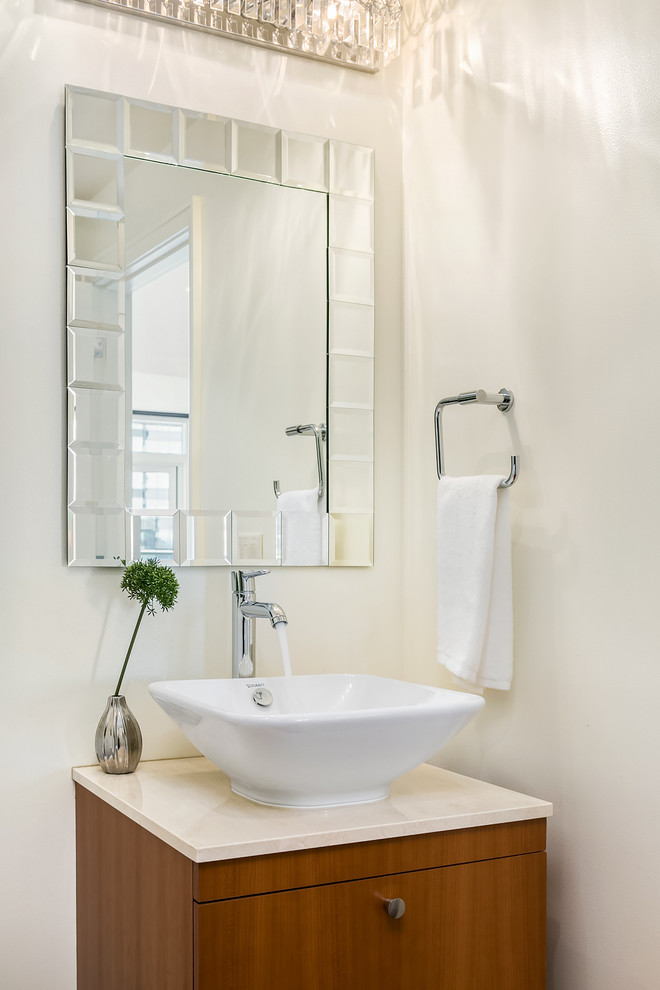 Esempio di un piccolo bagno di servizio contemporaneo con ante lisce, ante in legno bruno, pareti bianche, lavabo a bacinella e top in pietra calcarea