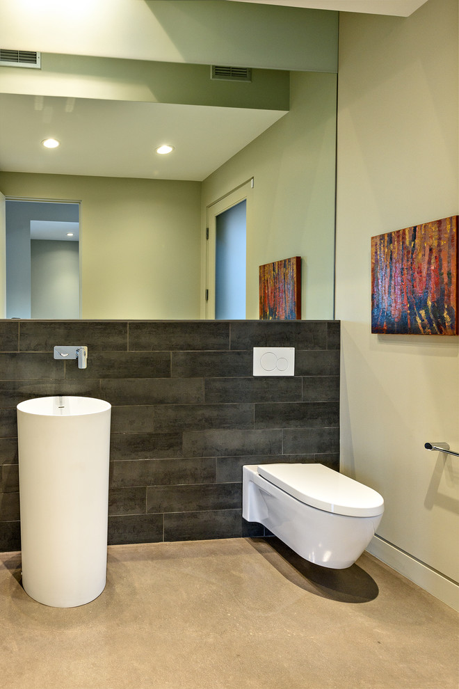Идея дизайна: туалет среднего размера в современном стиле с инсталляцией, серой плиткой, керамогранитной плиткой, бежевыми стенами, бетонным полом, раковиной с пьедесталом, столешницей из искусственного кварца и серым полом
