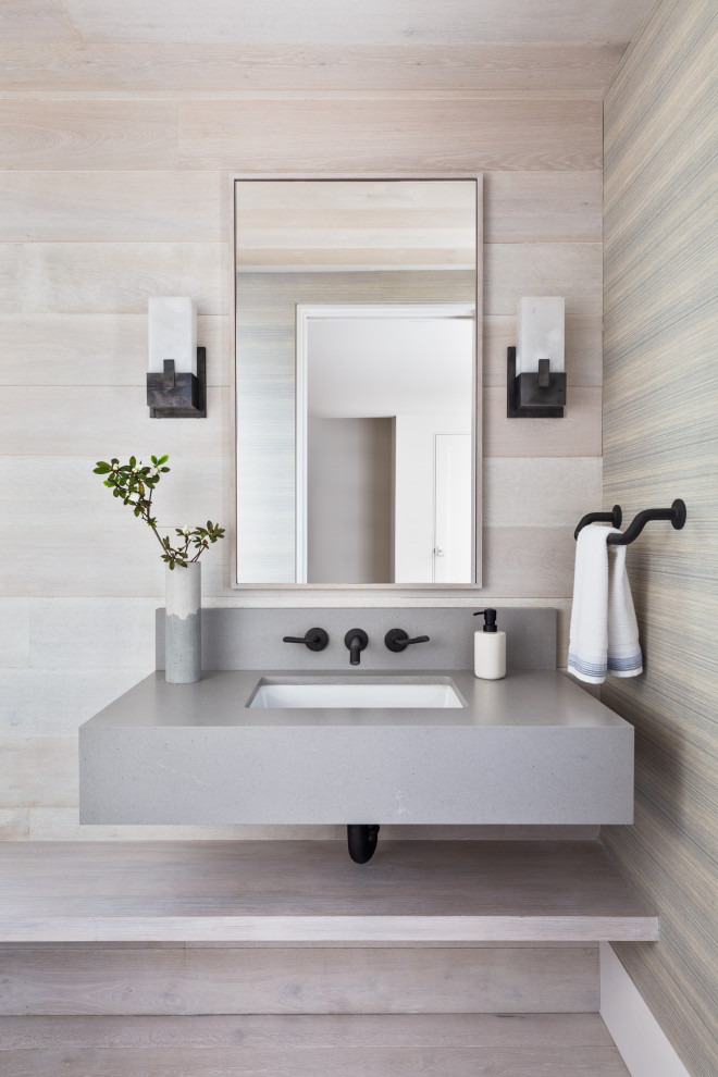 Réalisation d'un WC et toilettes design en bois avec parquet clair, un lavabo encastré, un sol beige et un plan de toilette gris.