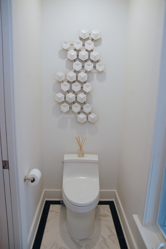 Cette image montre un petit WC et toilettes minimaliste avec WC à poser, un carrelage beige, un mur blanc, un sol en carrelage de céramique, un plafond à caissons, un placard à porte plane, des portes de placard marrons, un lavabo encastré, un plan de toilette en marbre, un sol beige, un plan de toilette blanc et meuble-lavabo suspendu.