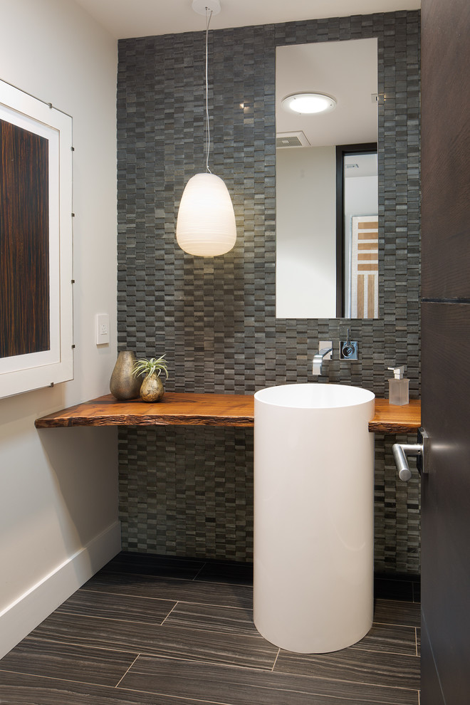 Идея дизайна: туалет в современном стиле с серой плиткой, серыми стенами, раковиной с пьедесталом, столешницей из дерева, серым полом и коричневой столешницей
