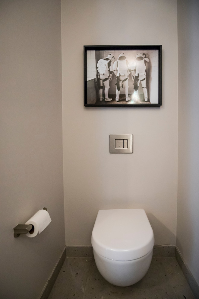 Inspiration for a small modern cloakroom in Toronto with a wall mounted toilet, grey walls, concrete flooring and grey floors.