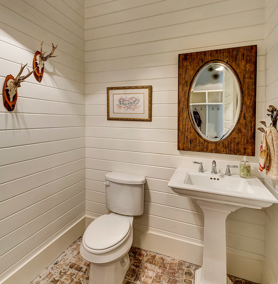 ダラスにあるカントリー風のおしゃれなトイレ・洗面所 (ペデスタルシンク、白い壁、レンガの床) の写真