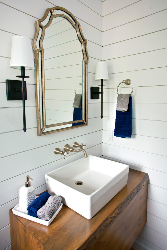 Imagen de aseo campestre pequeño con paredes blancas, suelo de madera clara, lavabo sobreencimera, encimera de madera y suelo beige