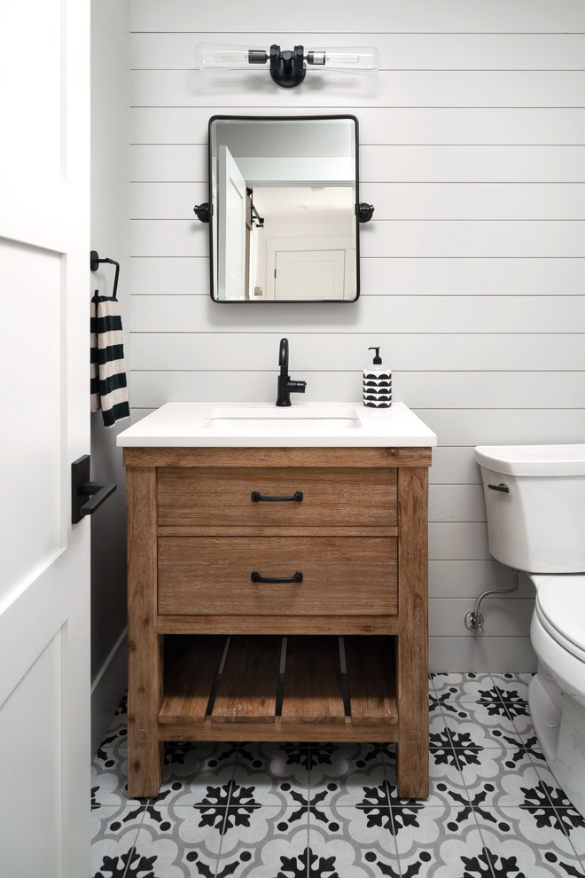 Example of a cottage porcelain tile powder room design in Denver with furniture-like cabinets, medium tone wood cabinets, gray walls, an undermount sink, quartz countertops and white countertops