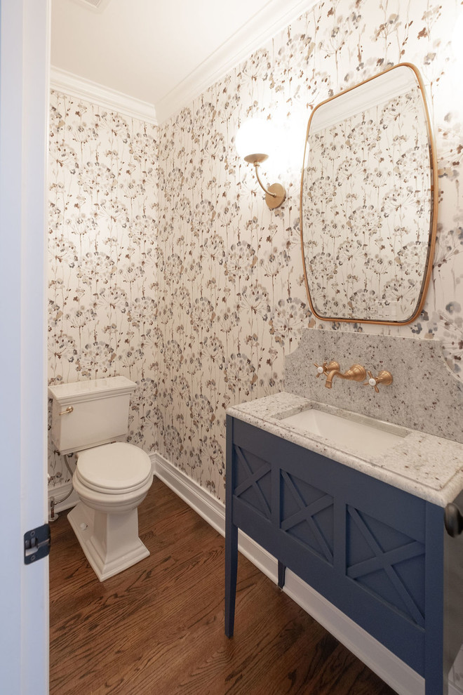 Idée de décoration pour un WC et toilettes champêtre de taille moyenne avec un placard en trompe-l'oeil, des portes de placard bleues, WC séparés, un mur multicolore, un lavabo encastré, un sol marron et parquet foncé.
