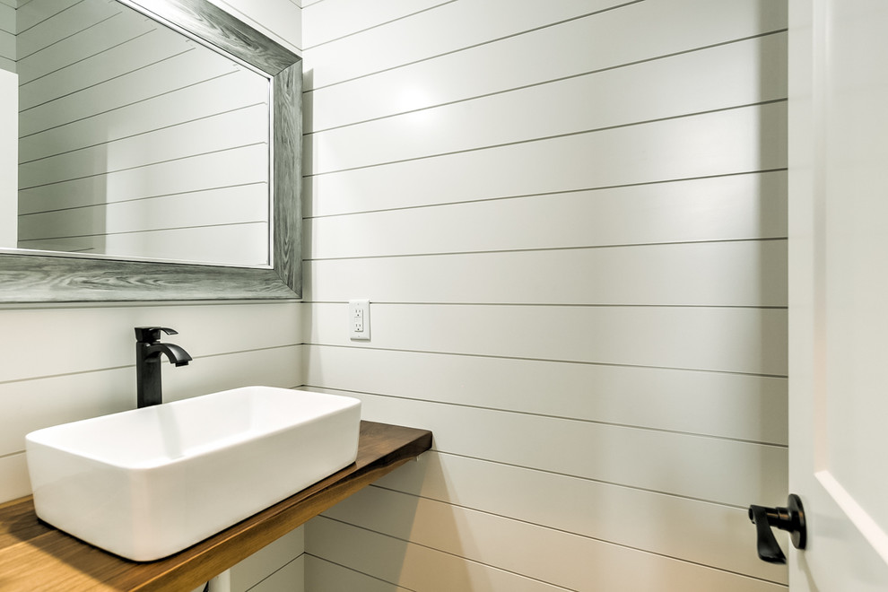 Kleine Country Gästetoilette mit Toilette mit Aufsatzspülkasten, weißer Wandfarbe, Keramikboden, Trogwaschbecken, Waschtisch aus Holz und schwarzem Boden in Boise