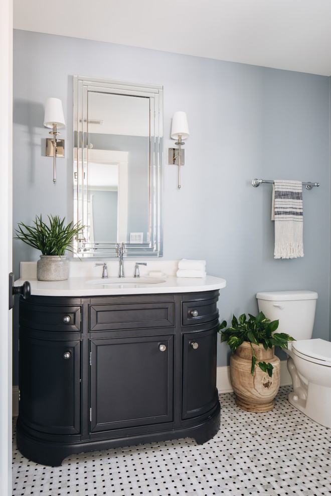 Landhaus Gästetoilette mit verzierten Schränken, schwarzen Schränken, blauer Wandfarbe, Mosaik-Bodenfliesen, Unterbauwaschbecken und weißer Waschtischplatte in Chicago