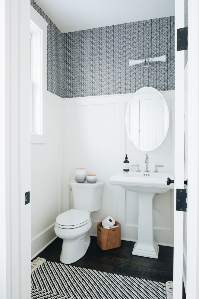Imagen de aseo campestre con sanitario de dos piezas, paredes grises, suelo de madera oscura, lavabo con pedestal y suelo marrón
