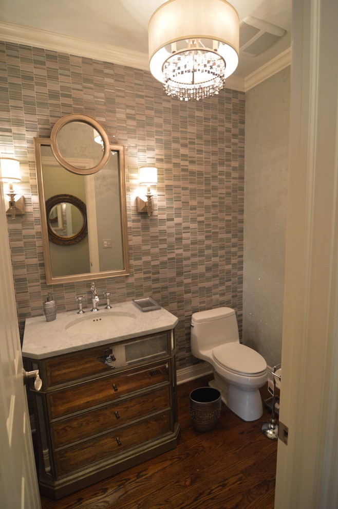 Photo of a medium sized bohemian cloakroom in Chicago with freestanding cabinets, a one-piece toilet, multi-coloured tiles, mosaic tiles, grey walls, medium hardwood flooring, a submerged sink, marble worktops and brown floors.