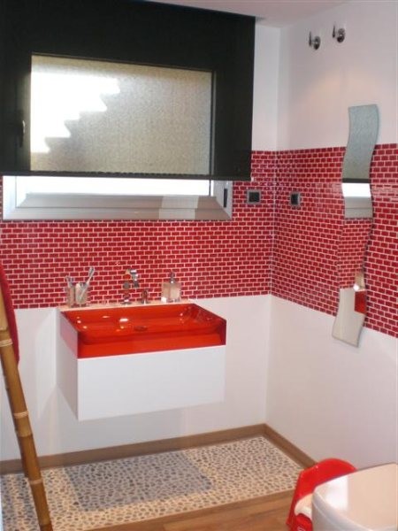 Aménagement d'un petit WC et toilettes éclectique avec un mur multicolore, un sol en bois brun, un placard à porte plane, des portes de placard blanches, WC séparés, un carrelage rouge, des carreaux de porcelaine, une vasque et un plan de toilette en quartz modifié.
