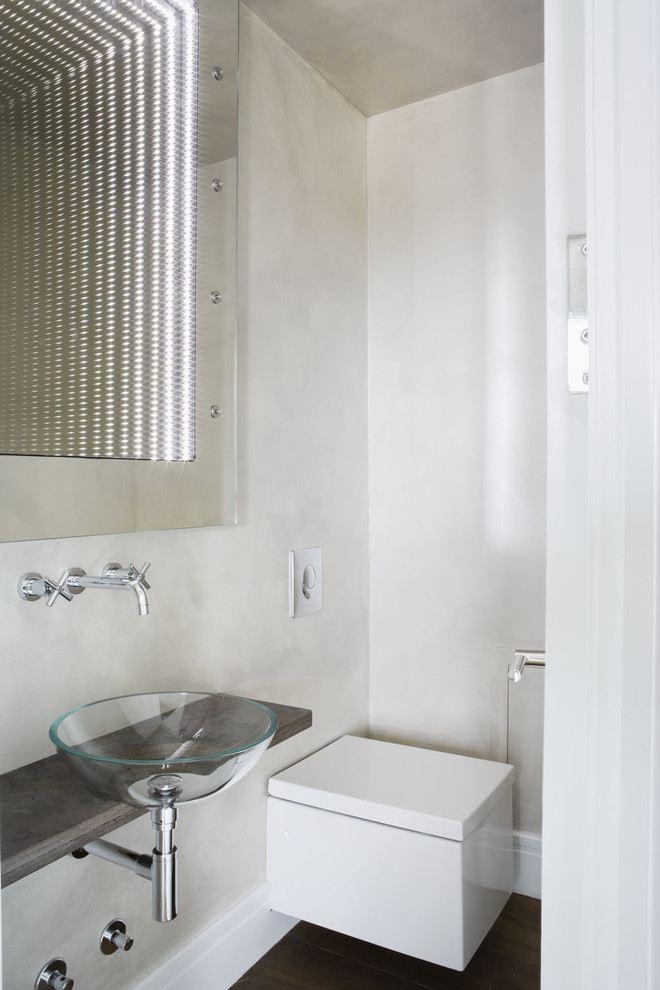 Ejemplo de aseo minimalista con lavabo sobreencimera y sanitario de pared