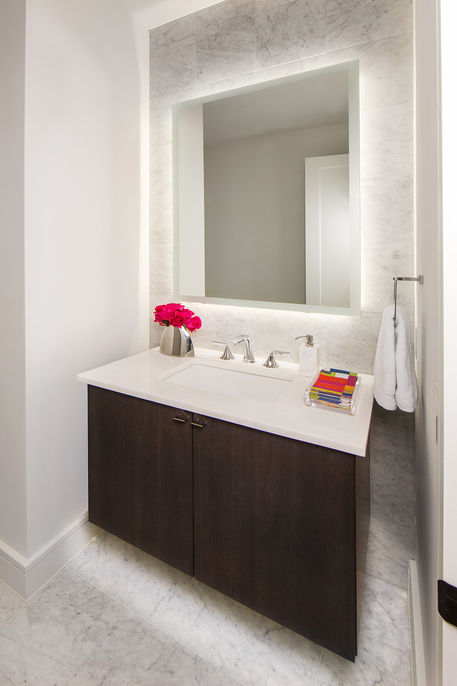 Idéer för ett litet modernt vit toalett, med släta luckor, skåp i mörkt trä, grå kakel, marmorkakel, grå väggar, mellanmörkt trägolv, ett undermonterad handfat, bänkskiva i akrylsten och brunt golv