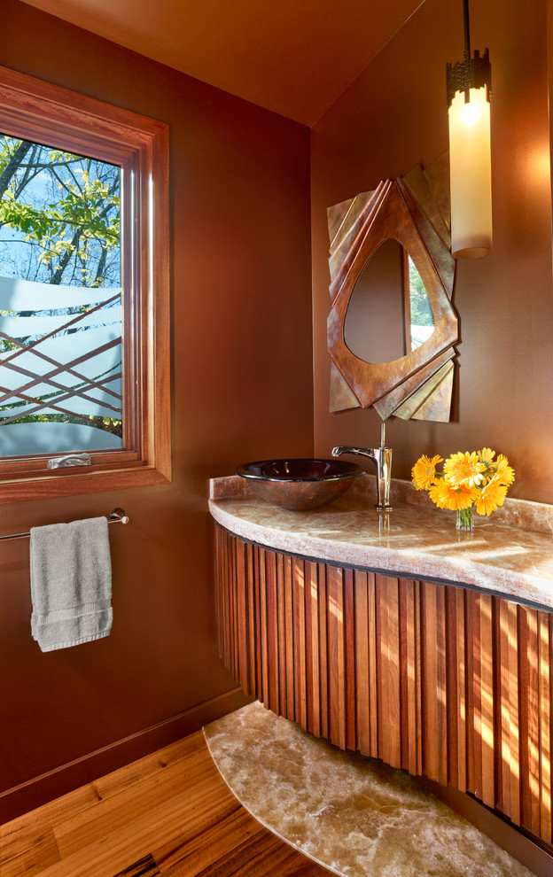 Inspiration för ett litet funkis toalett, med möbel-liknande, skåp i mellenmörkt trä, mellanmörkt trägolv, ett fristående handfat, bänkskiva i onyx, bruna väggar och orange golv