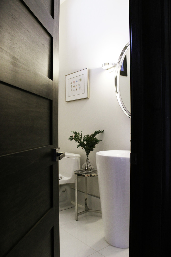 Diseño de aseo minimalista pequeño con sanitario de una pieza, paredes blancas, suelo de baldosas de porcelana, lavabo con pedestal y suelo blanco